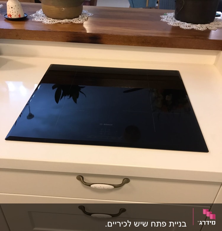 משטח שיש לבן עם כיריים שחורות